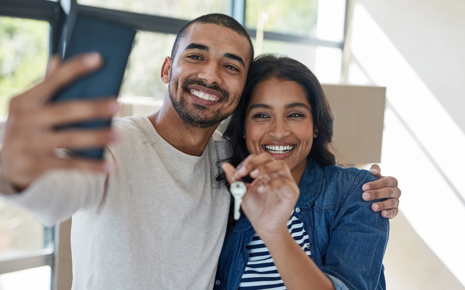 Shot of a happy young couple taking a selfie while moving into their new house together.